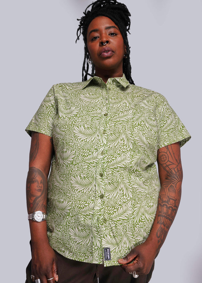1X=Person wearing a green patterned shirt against a plain background