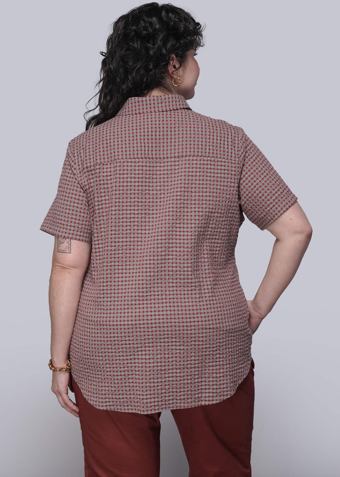 1X=Person wearing a checkered shirt and red pants on a white background