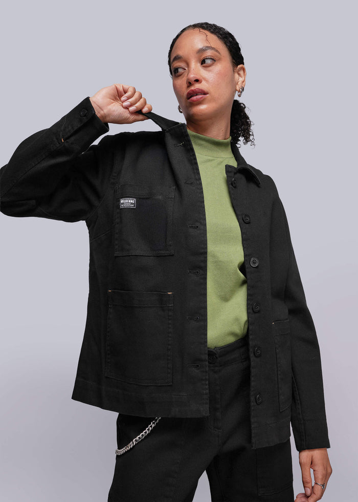 S=Person wearing a black denim jacket with a visible brand logo on a plain background
