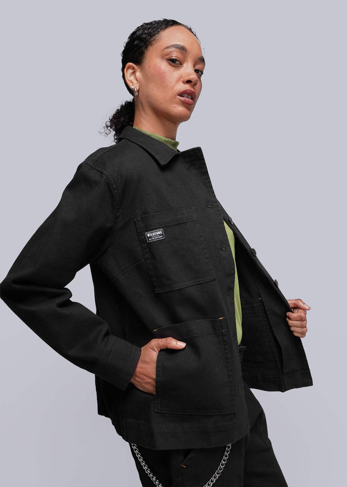 S=Person wearing a black jacket with a visible brand logo on a light gray background