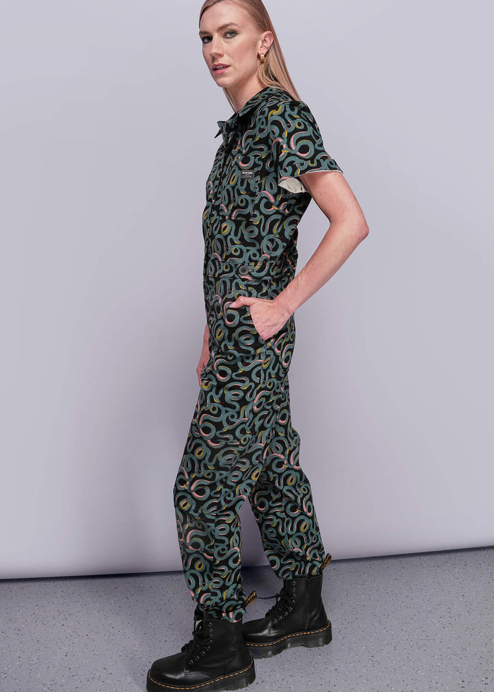 S=Person wearing a patterned jumpsuit on a plain background