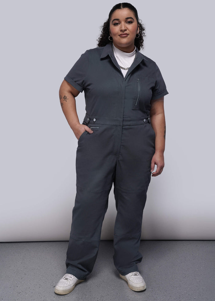 1X=Person wearing a black jumpsuit against a plain background