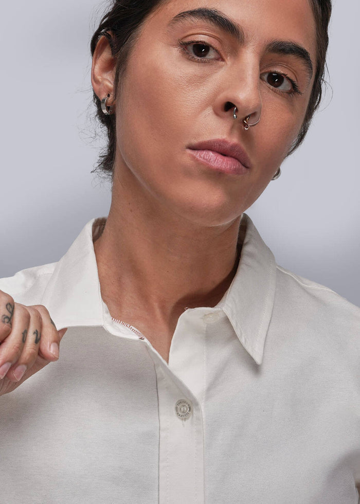 S=Person wearing a white shirt against a plain background