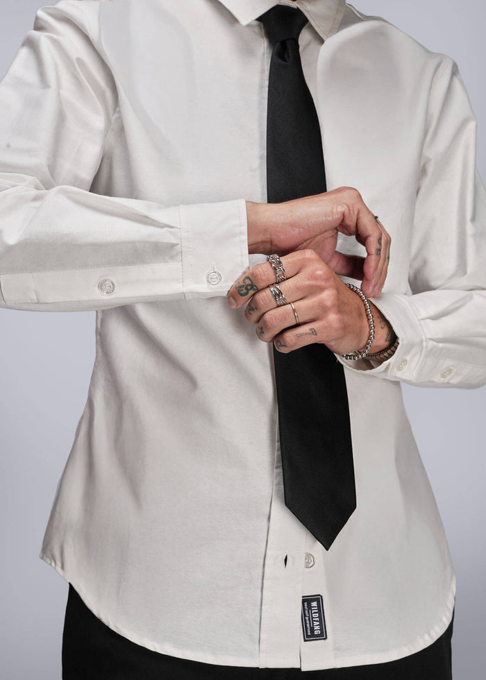 S=Person wearing a white dress shirt with a black tie against a plain background