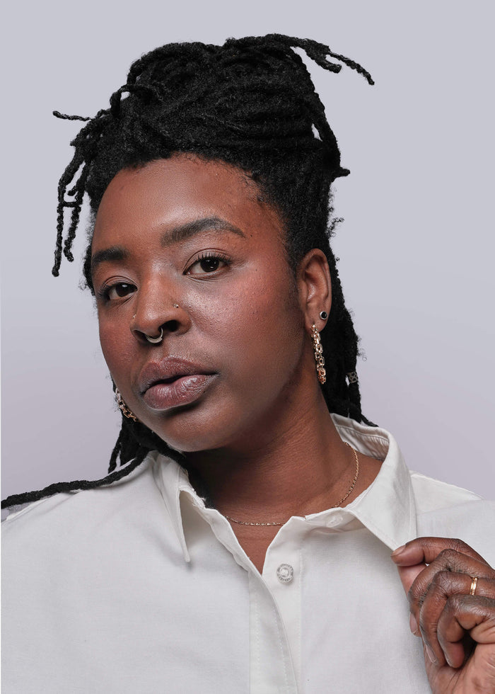 1X=Close up of Person wearing a white shirt against a plain background