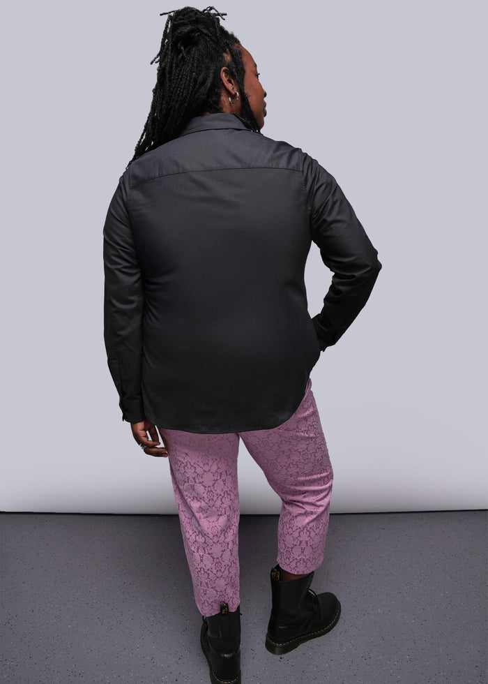 1X=Person wearing a black jacket and pink pants against a white background