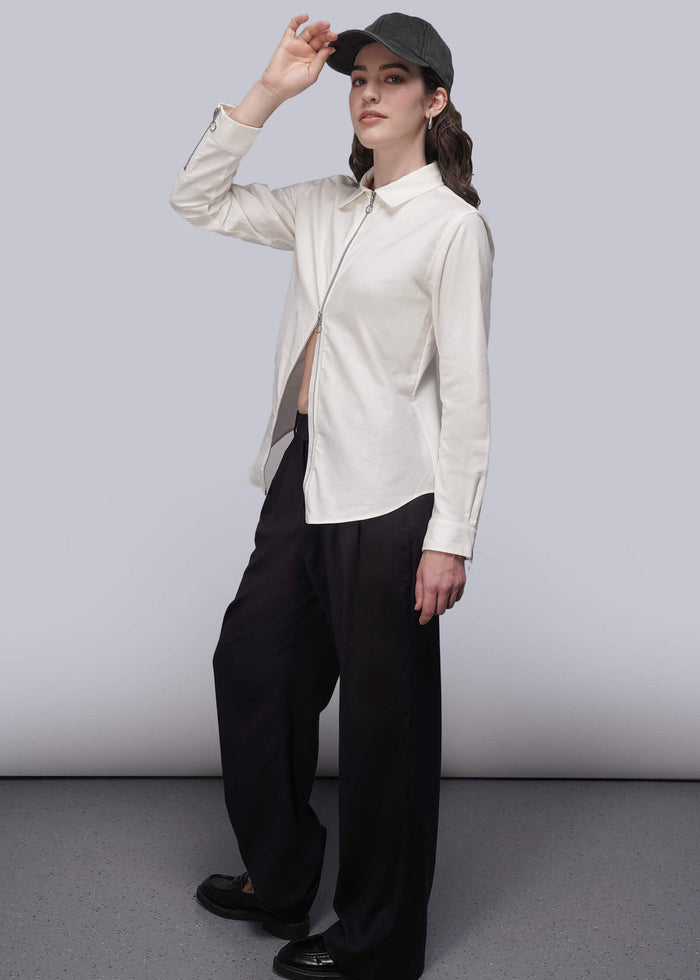 S=Person wearing a white shirt and black pants with a cap against a plain background
