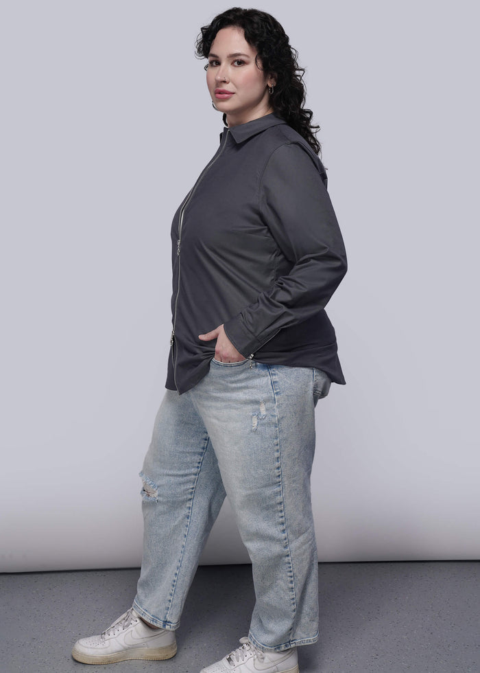 1X=Person wearing a black shirt and light blue jeans against a plain background