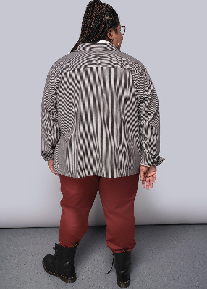 1X=Person wearing a brown and white striped striped jacket and red pants against a white background