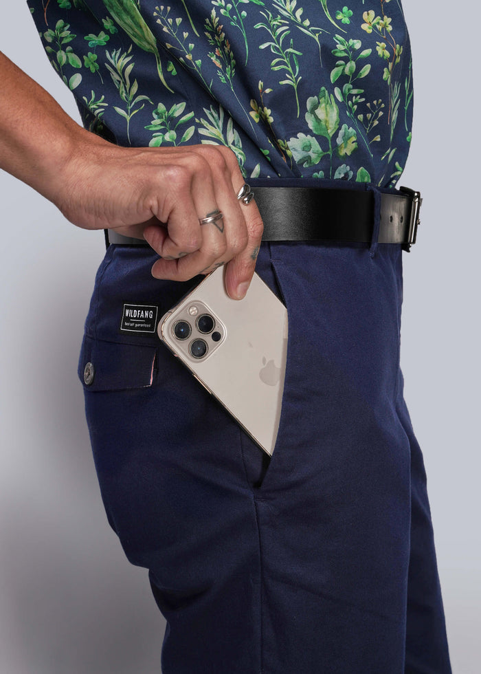 S=Person wearing navy pants with a floral shirt, holding an iPhone in a pocket.