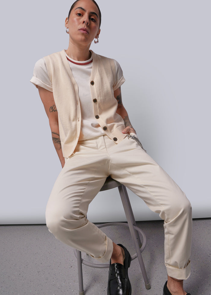 S=Person wearing a beige outfit with a white background