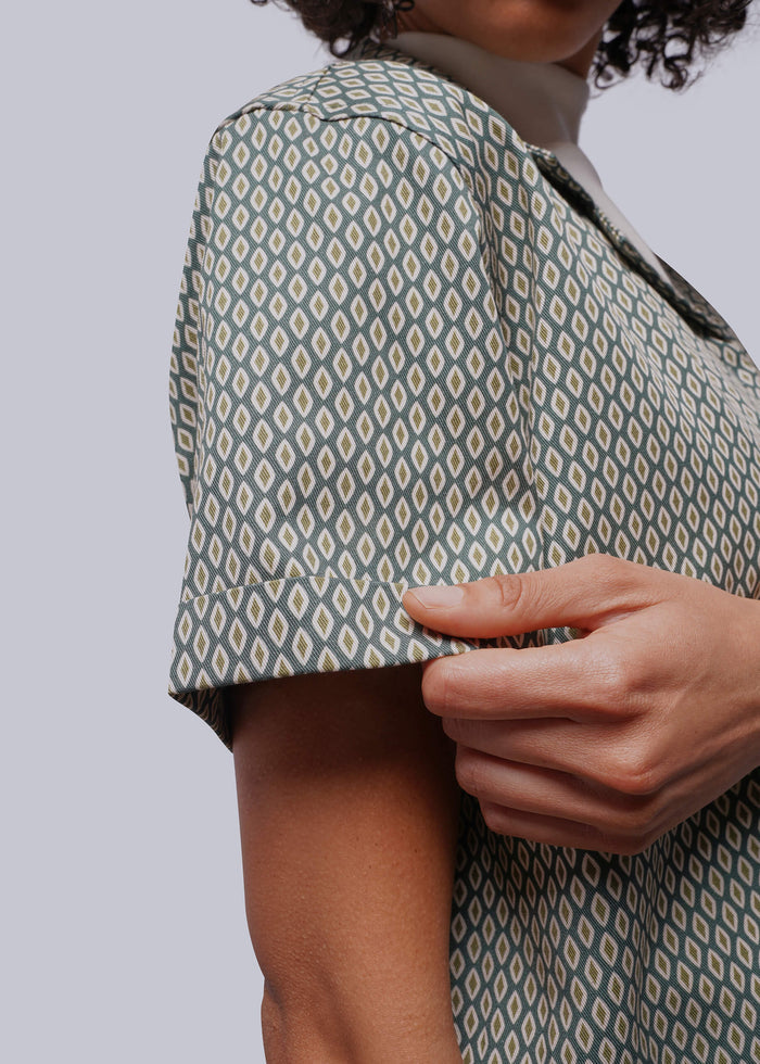 S=Person wearing a patterned shirt with a plain background