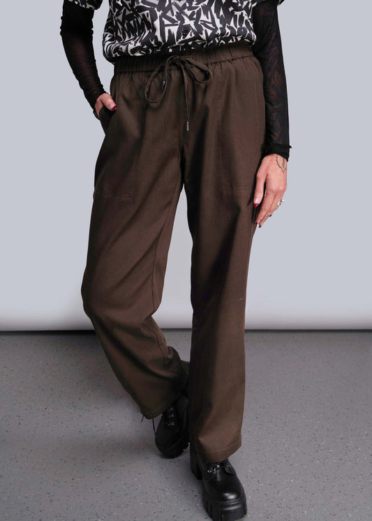 S=Person wearing brown pants and black shoes on a plain background