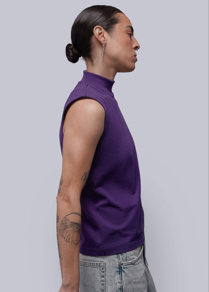 S=Person wearing a purple sleeveless top against a plain background