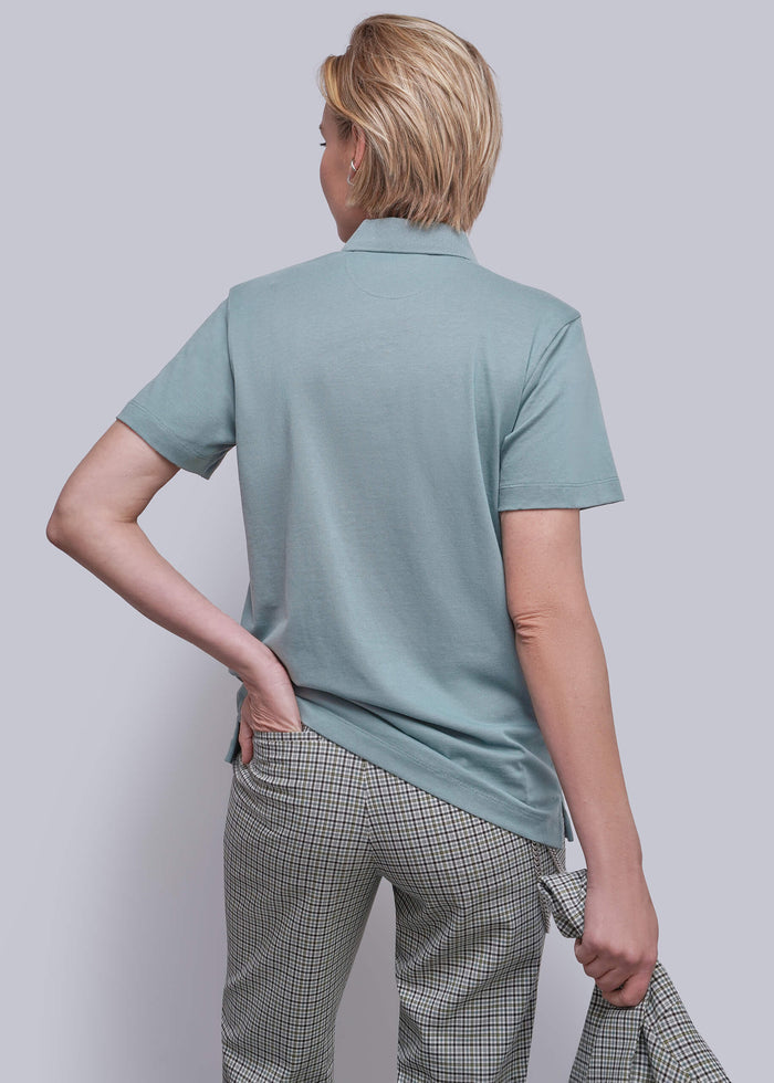 S=A model shown from the back wearing a short-sleeve polo shirt in a teal color, paired with gray and white checkered trousers, against a solid light gray background.