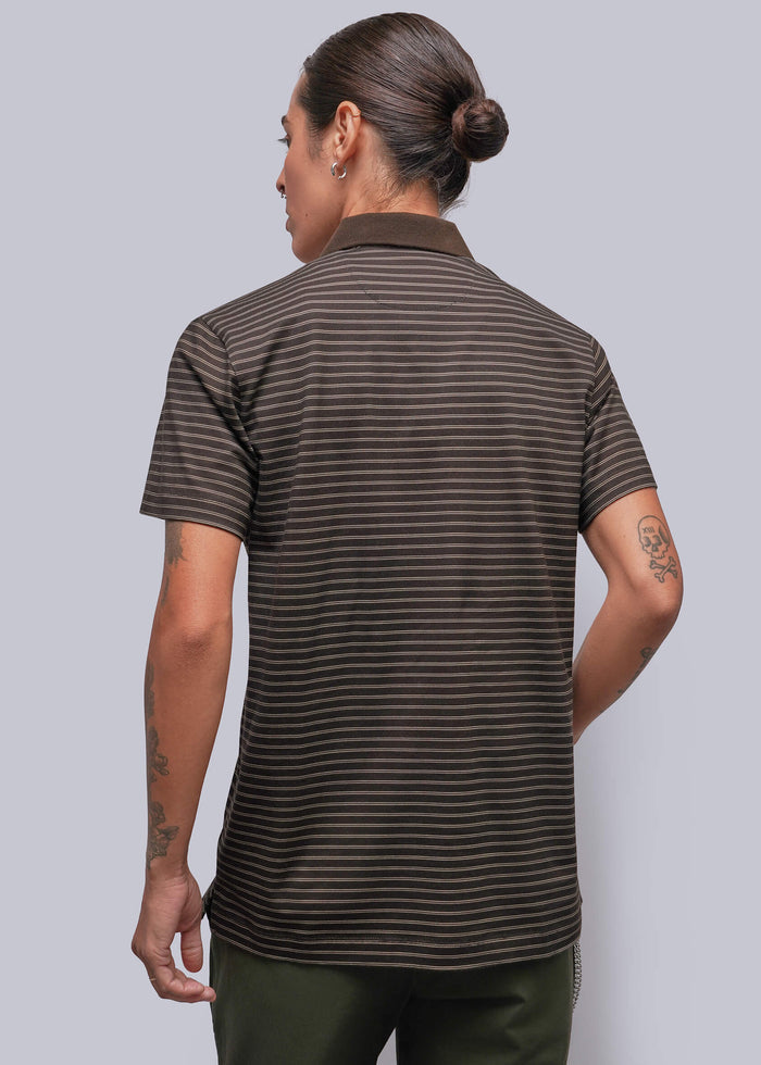 S=A person viewed from the back wearing a short-sleeve polo shirt with thin horizontal dark brown and black stripes, paired with dark olive pants, against a solid gray studio background.