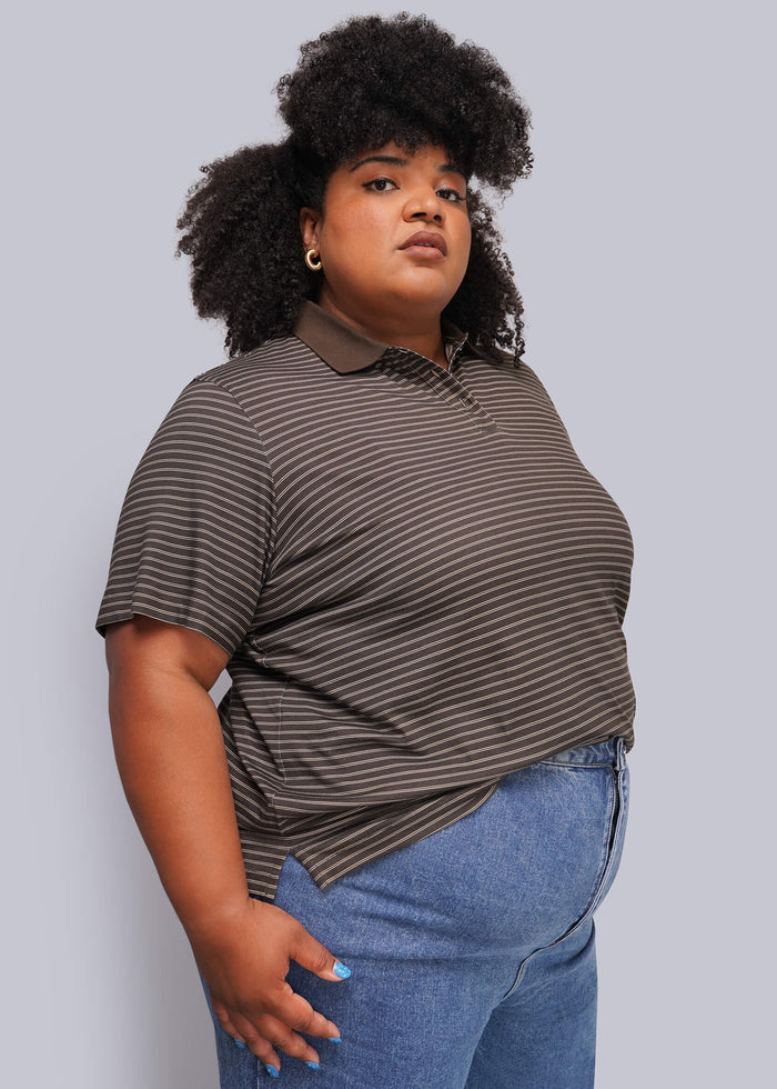 1X=A plus-size model wearing a brown and dark gray striped short-sleeve polo shirt with blue jeans, standing against a solid gray studio background.