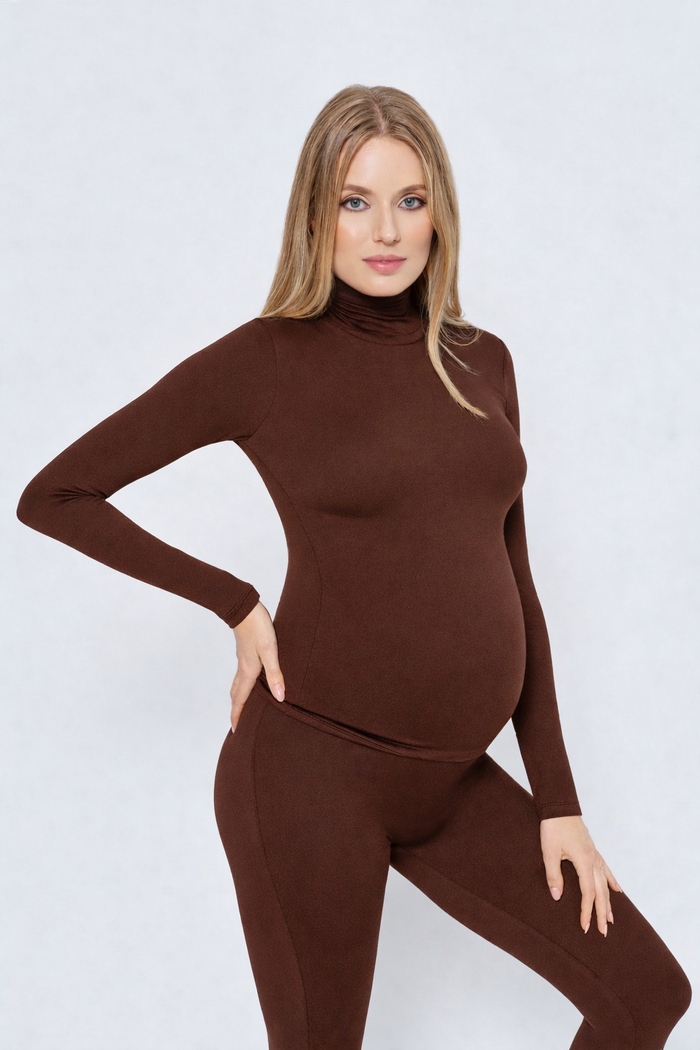 Woman wearing a brown turtleneck and leggings set on a white background