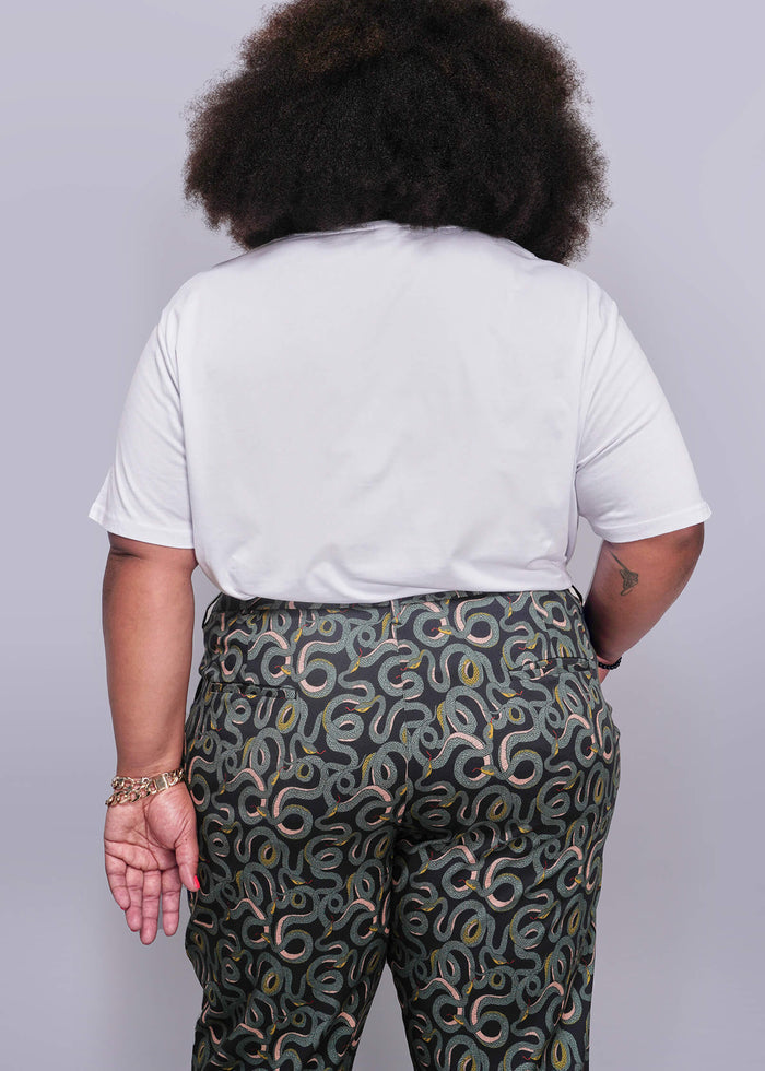 1X=Person wearing a white t-shirt and patterned pants on a plain background