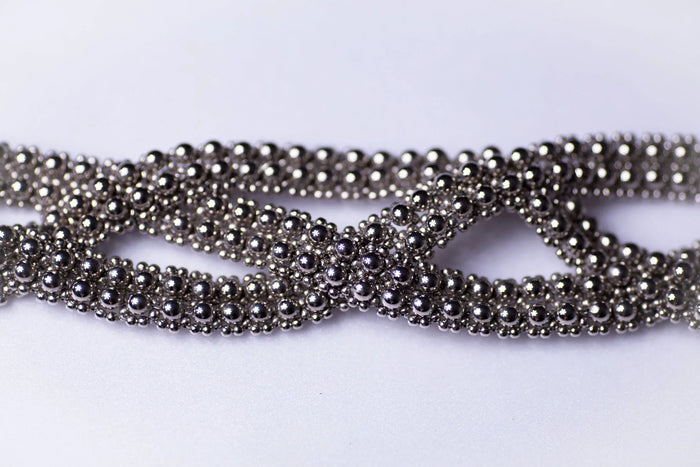 detail beads of trinity modular hat from polymer metal beads on white background