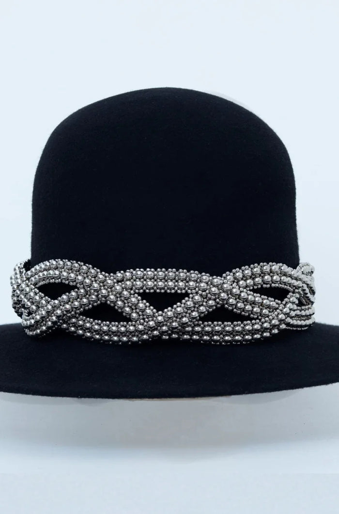 Beaded modular accessory on black hat from polymer metal beads by object and dawn on neutral background